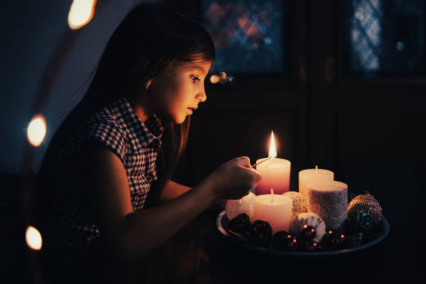 девушка на рождество, девушка в церкви, девушка зажигает свечу - candle advent christmas church стоковые фото и изображения