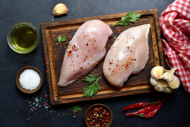 istock Raw organic chiken breasts with ingredients for making. Top view with copy space. 1747069495