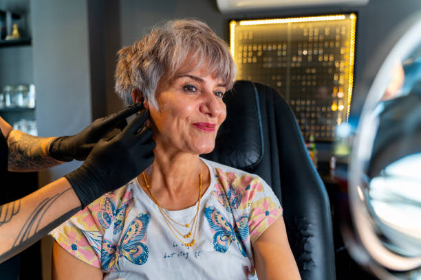 istock ear piercing, elderly woman gets pierced 1747070041