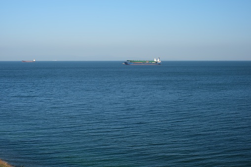 High angle view of single big cargo ship on sea over sunny blue sky