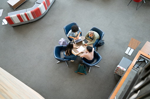Overhead view of university students working on round table in student center