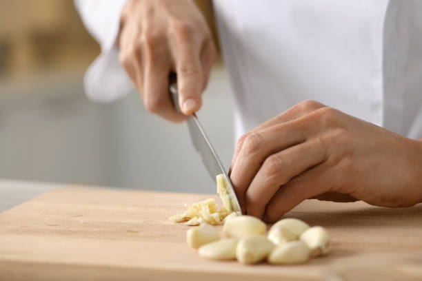 istock Professional chef cutting garlic at table indoors, closeup 1747092179