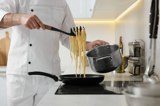 istock Professional chef cooking delicious pasta on stove in kitchen, closeup 1747093261