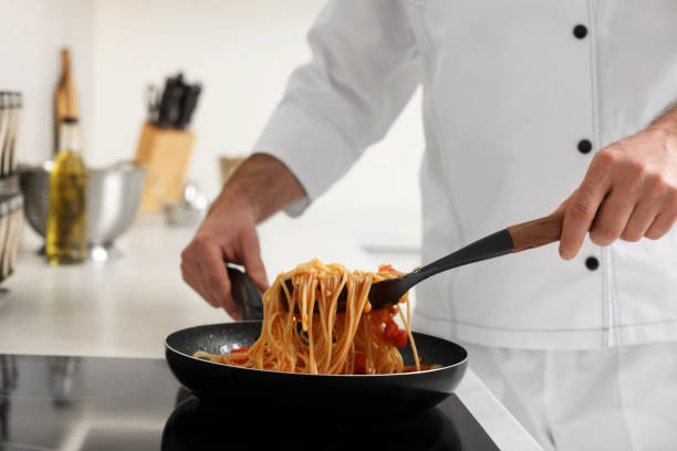istock Professional chef cooking delicious pasta on stove in kitchen, closeup 1747093392