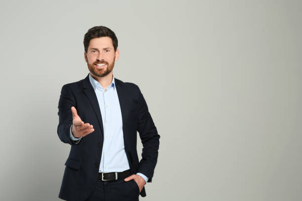 istock Handsome real estate agent in nice suit on grey background, space for text 1747096505
