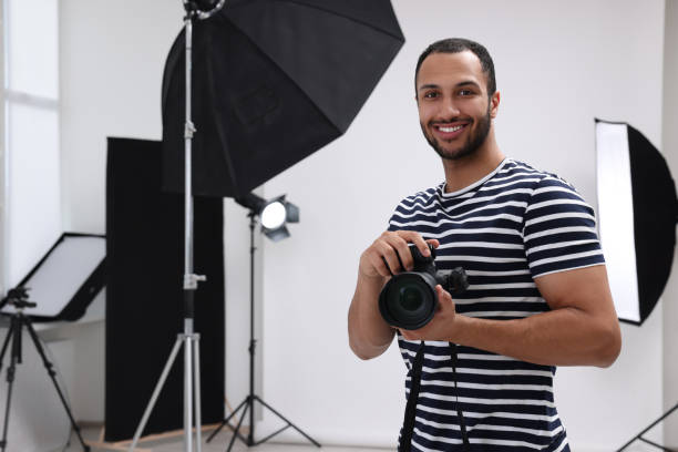 istock Young professional photographer with camera in modern photo studio, space for text 1747112616