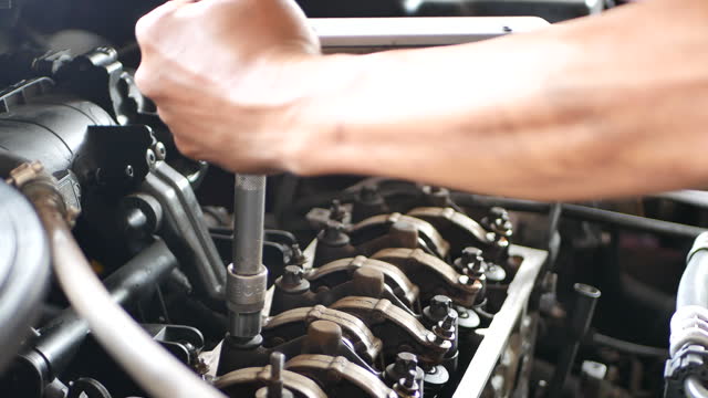 A mechanic working on car engine. Car auto services and maintenance check concept