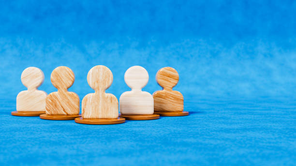 istock Five wooden figures as people icons on a blue stage, teamwork and community theme, 3d illustration 1747201523