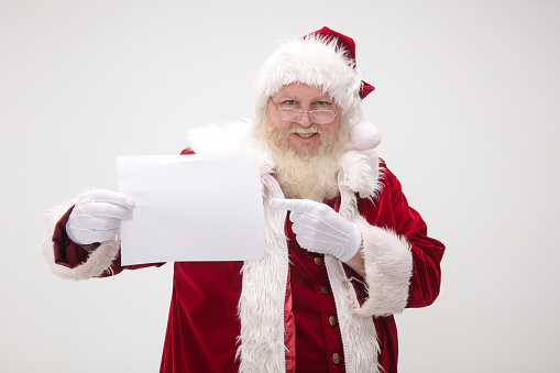 Santa Claus holding up and pointing to a blank sign