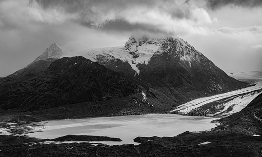 Clouds rolling in over a mountain and glacier, located in Wrangell St. Elias National Park.