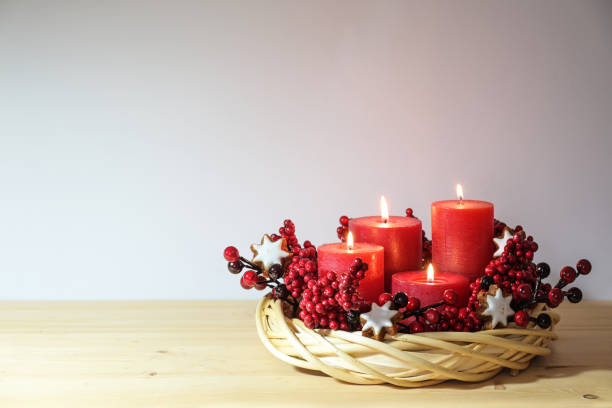 istock Fourth advent with four lit red candles in a natural willow wicker wreath with cinnamon star cookies and artificial berries, holiday decoration, copy space, selected focus 1747292870