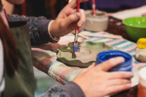 istock Pottery lesson master class for kids children, process of making clay pot on pottery wheel, potter hands creating ceramic crockery handcrafts, ceramist molding and painting jar or vase 1747377882