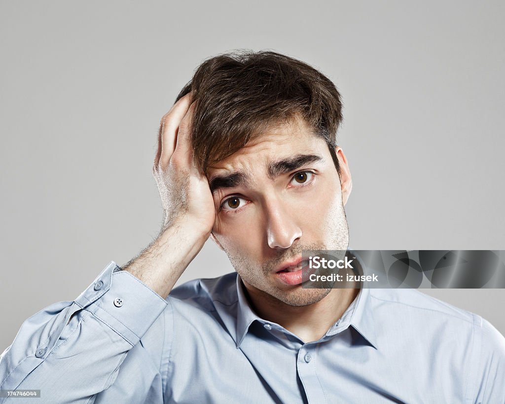 Worried businessman Portrait of worried businessman looking at camera with hand on head. Frustration Stock Photo