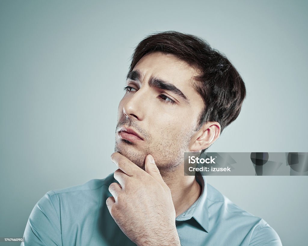 Contemplation Portrait of serious businessman looking away and thinking with his hand on chin. 25-29 Years Stock Photo