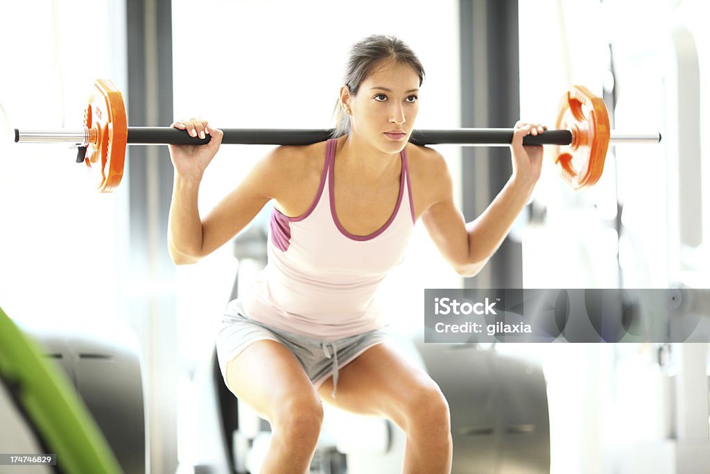 Frau machen Kniebeugen in einem Fitnessstudio - Lizenzfrei Aktiver Lebensstil Stock-Foto