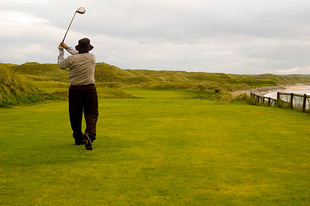 Golfer hitting golf ball out of sand trap on course