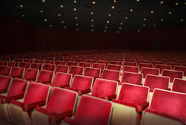 istock Empty Theater with Rows of Red Seats and Ceiling Lights 174749525