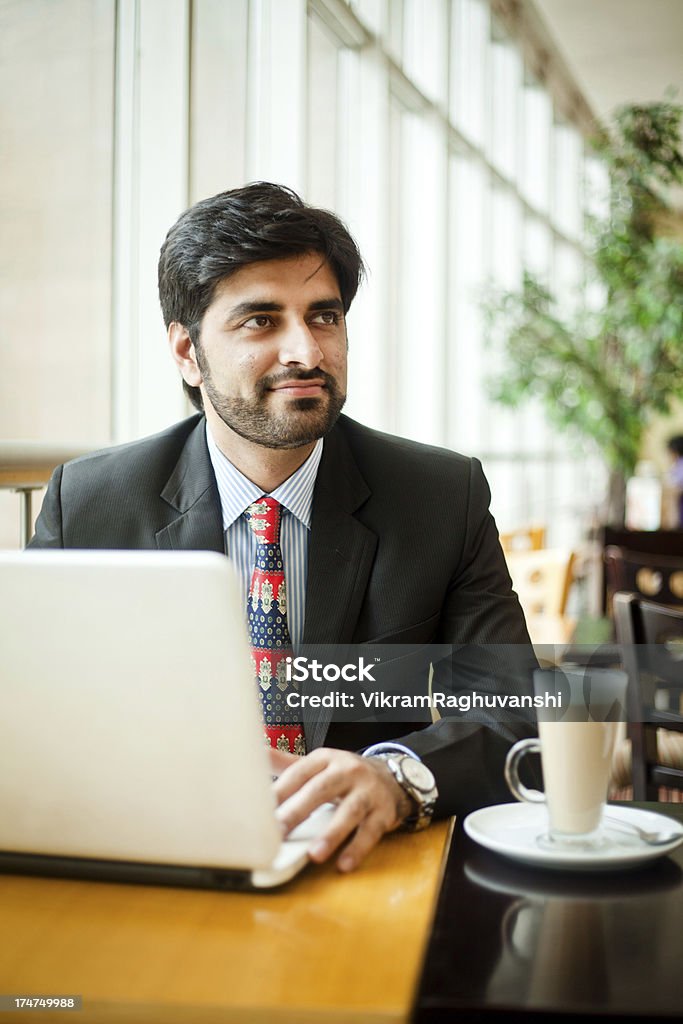 Giovane asiatica indiana Uomo d'affari che lavorano su computer portatile in caffetteria - Foto stock royalty-free di Istantanea