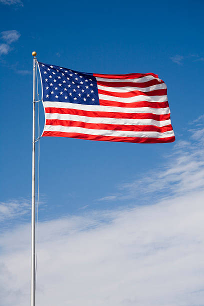 US flag against blue sky stock photo