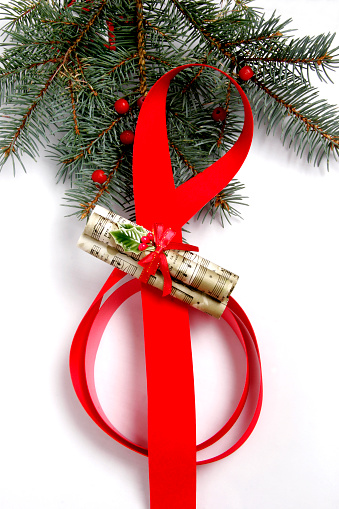 The familiar music treble clef supports a scroll of Christmas carols while highlighted by Spruce needles and red berries.