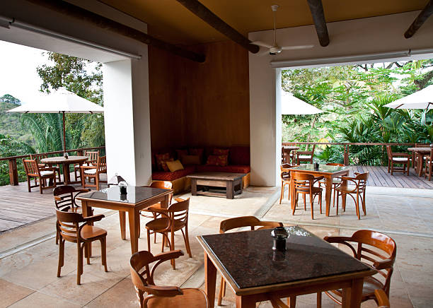 istock luxury hotel: tables and chairs against lush vegetation background 174751998