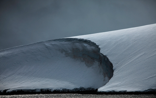 A dark and moody photo of an Antarctica shoreline.