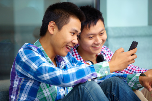 picture of two happy young men sharing funning things on mobile phone