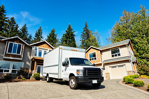 Plain White Moving Truck in Driveway Photo of a plain white moving truck parked in the driveway of a modern home. driveway photos stock pictures, royalty-free photos & images