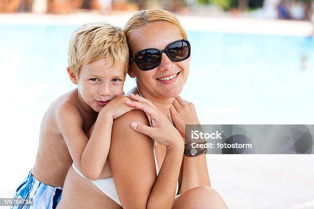 Madre E Hijo Se Relaja Junto A La Piscina Foto de stock y más banco de imágenes de Adulto - Adulto, Agua, Cómodo - Conceptos