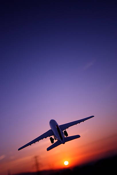 Airplane Flying Up Against The Sunset.