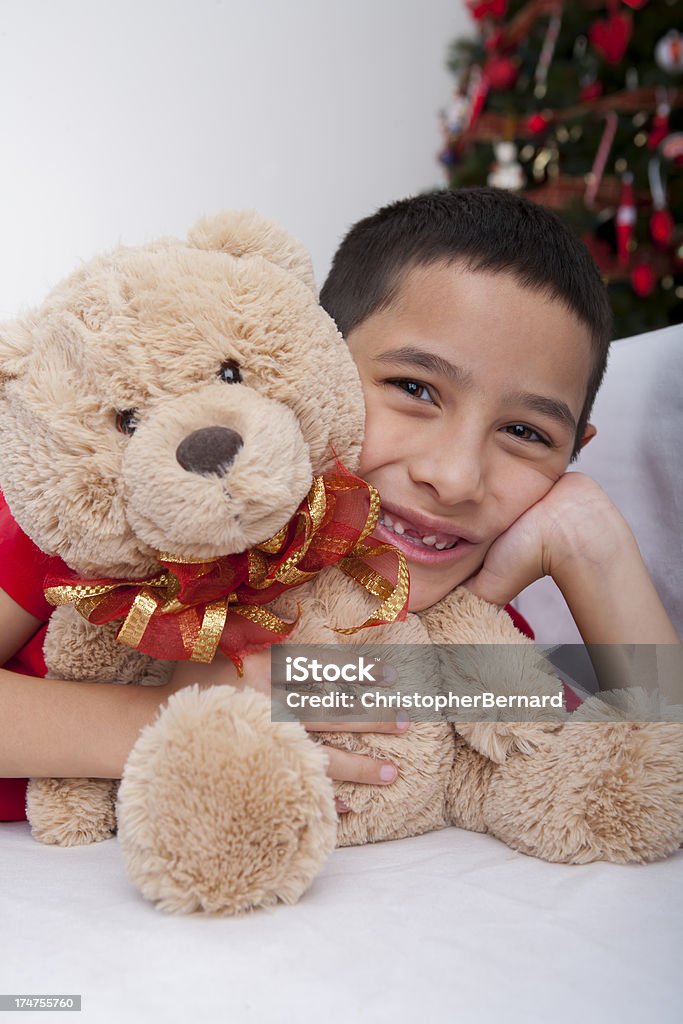 Noël garçon souriant embrassant ours en peluche - Photo de 8-9 ans libre de droits