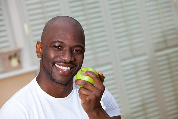 istock Young man with great teeth eating a juicy green apple 174755818