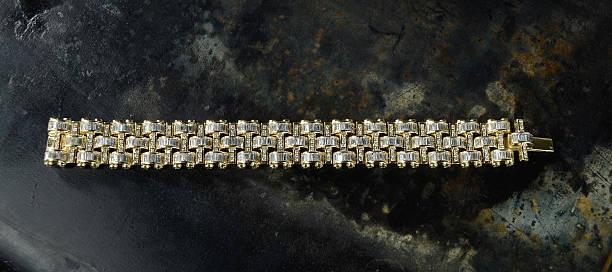 Expensive diamond and gold bracelet on a discolored metal background.