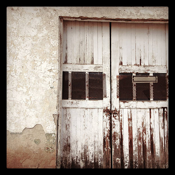 old white washed doors "old white washed doors on old building exterior wall.  mobilestock square composition with black border taken in the small town of cuba, new mexico." black border photos stock pictures, royalty-free photos & images