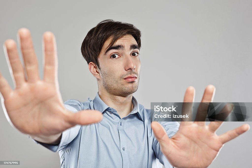 Stop Portrait of young scared businessman looking at the camera with and gesturing stop. Focus on male face. 25-29 Years Stock Photo
