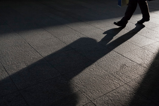 Feet of those who walk in the backlight.