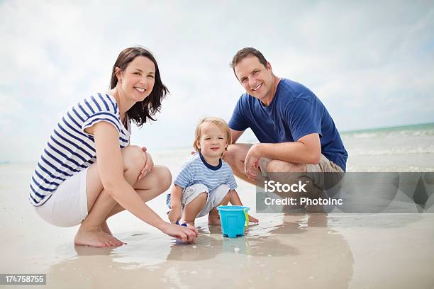 Bambino E Genitori Giocando Nella Sabbia In Spiaggia - Fotografie stock e altre immagini di 30-34 anni