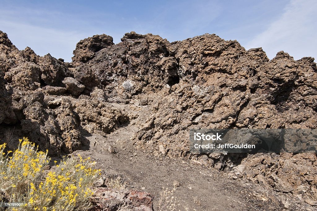 Volcanic Rock at Fleener Chimnies Lava Beds National Monument is a land with a tumultuous past, both geological and historical. Over the last half-million years, this high desert has experienced volcanic eruptions, creating a very rugged landscape of lava tubes, fumaroles, spatter cones, pit craters, volcanic fields and cinder cones. In 1872 and 1873, the Modoc War took place in this area pitting a band of natives led by Kintpuash (also known as Captain Jack) against the army of the United States. The Fleener Chimneys are spatter cones created when very fluid particles of lava ejected from a volcanic vent fell back to the vent and plastered themselves together to form chimney like structures. The Fleener Chimneys are located in Lava Beds National Monument, California, USA. Ancient Stock Photo