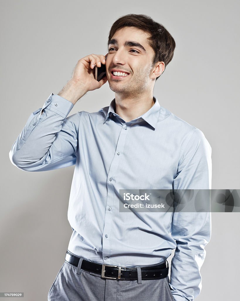 Young businessman on phone Portrait of young pleased businessman talking on mobile phone with his hand in a pocket. 25-29 Years Stock Photo