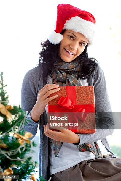 Mujer Joven Recibiendo Regalo De Navidad Foto de stock y más banco de imágenes de Adulto - Adulto, Adulto joven, Agarrar