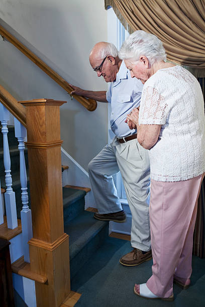 istock Senior woman helping husband climb staircase 174759047