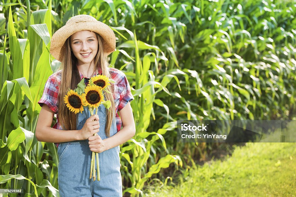 Garota jovem agricultor com girassóis o campo de fazenda - Foto de stock de 14-15 Anos royalty-free