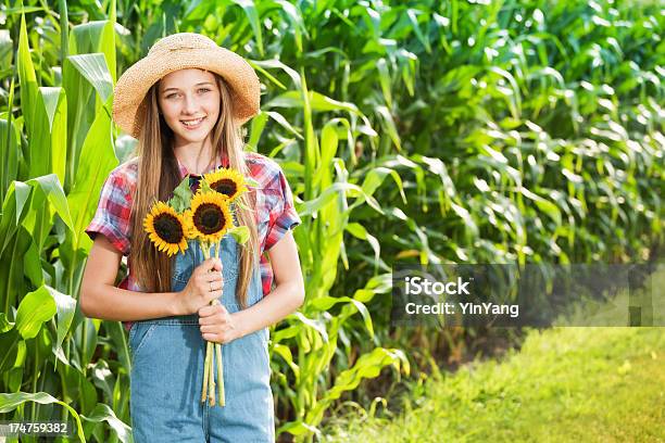 Foto de Garota Jovem Agricultor Com Girassóis O Campo De Fazenda e mais fotos de stock de 14-15 Anos