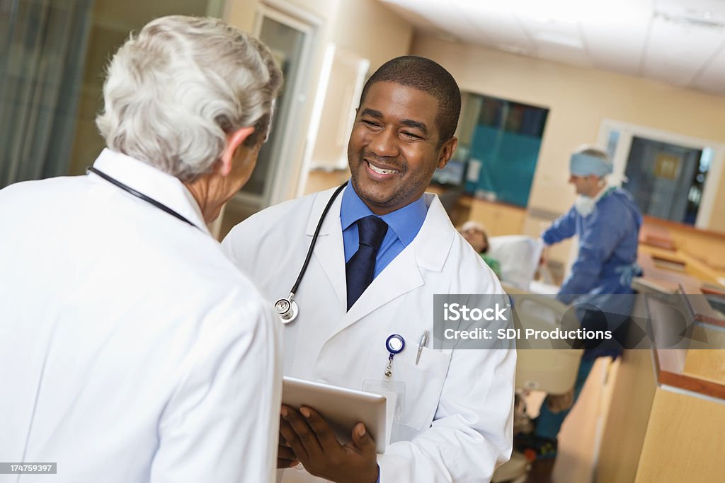 Médicos analizar la atención del paciente en el hospital corredor de negocios - Foto de stock de Accidentes y desastres libre de derechos