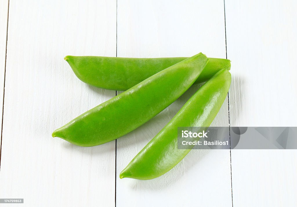 green pea pods three fresh green pea pods on a white background Close-up Stock Photo
