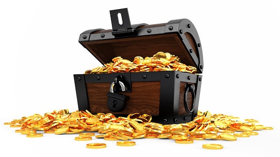 A wooden chest with an ajar lid filled with coins. Coins scattered on the sand.