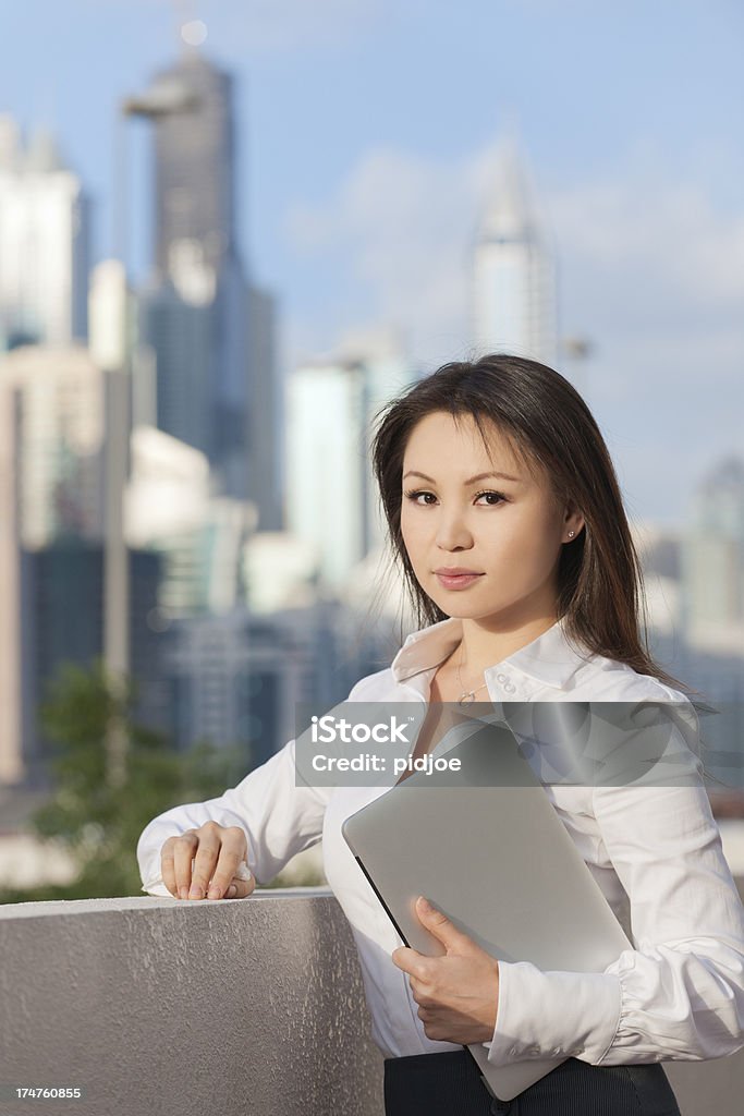 Mulher de negócios segurando um laptop em Dubai - Foto de stock de 25-30 Anos royalty-free