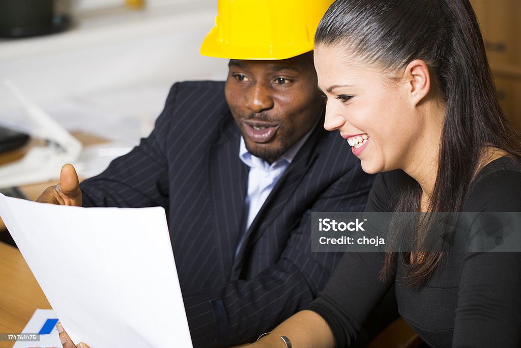 Arquitecto y examinando blueprints Ingeniero de la construcción - Foto de stock de Accesorio de cabeza libre de derechos