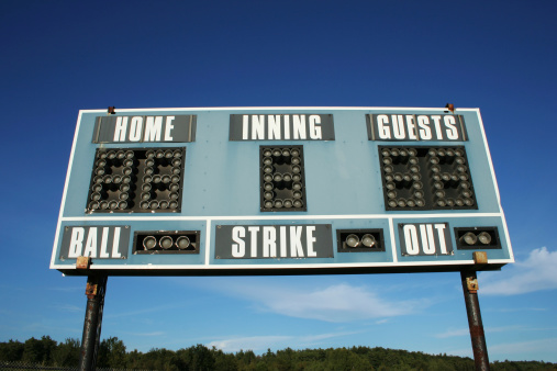 shot of baseball scoreboard against blue sky