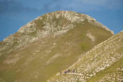 group of people walking in the mountains.
